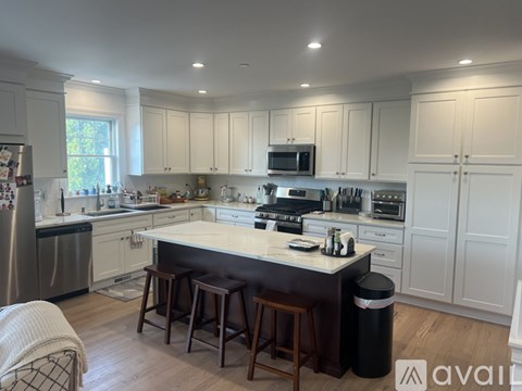 A kitchen with white cabinets and a large island.