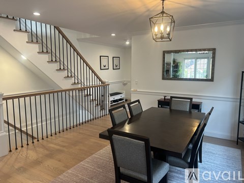 A dining room with a wooden table and chairs.