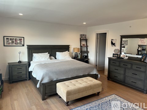A bedroom with a large bed and a bench in front of it.