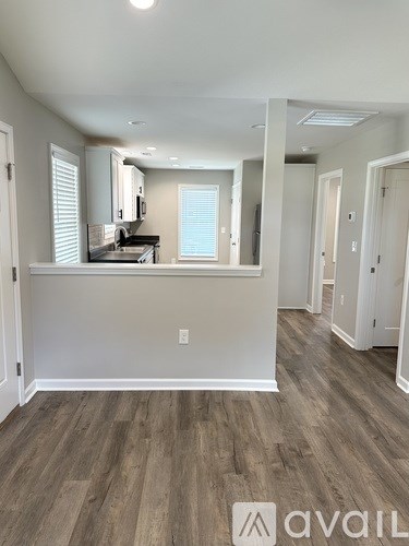 A room with wooden flooring and white walls.