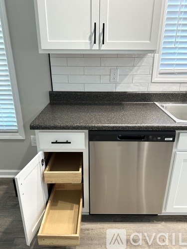 A kitchen with a dishwasher and a drawer pulled out.