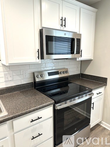 A kitchen with white cabinets and a black oven.