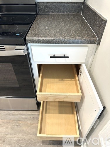 A kitchen counter with a drawer pulled out.