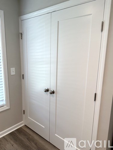A white double door with a silver handle is closed.