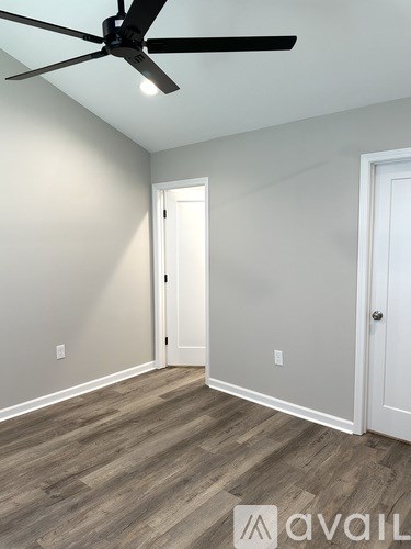 A room with a ceiling fan and two doors.