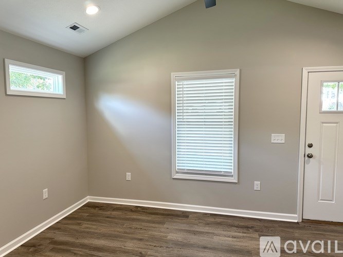 A room with a window and a door is available for rent.