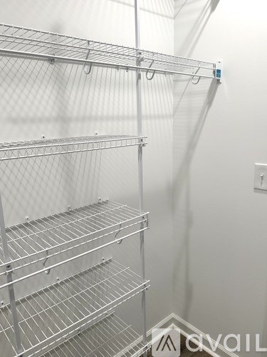 A white wall with a metal shelf attached to it.