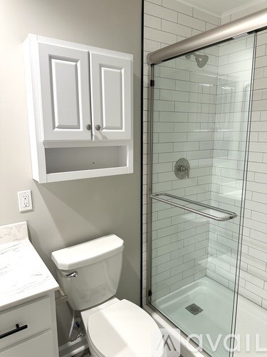 A white toilet in a bathroom with a glass shower door.