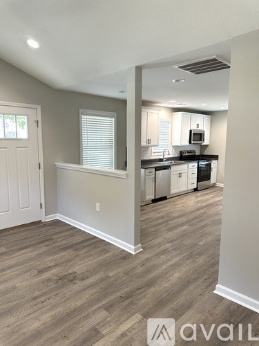 A kitchen with a white door and a window with blinds.