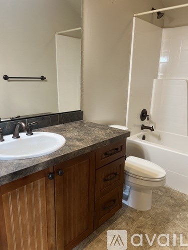 A bathroom with a toilet, sink, and bathtub.