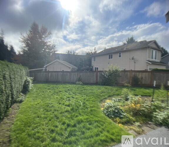A backyard with a fence and a house in the background.