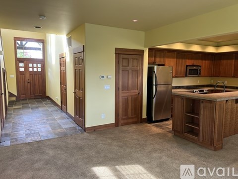A kitchen with wooden cabinets and a refrigerator.