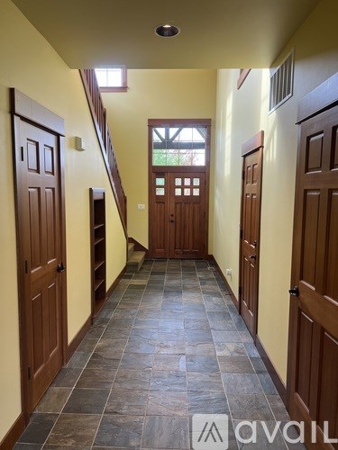A hallway with wooden doors and a tiled floor.