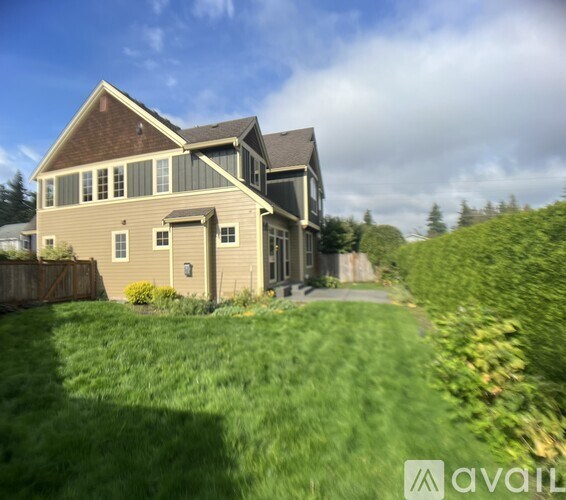A house with a brown roof and a green lawn in front.