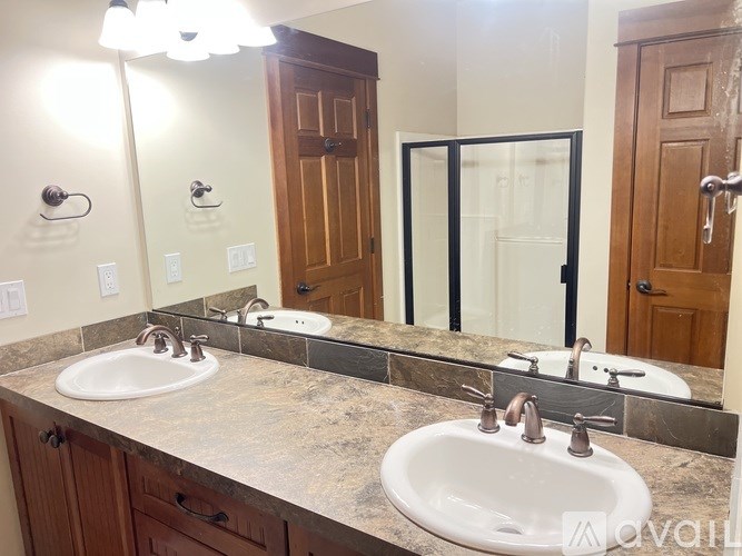 A bathroom with two sinks and a large mirror.