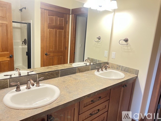 A bathroom with two sinks and a large mirror.