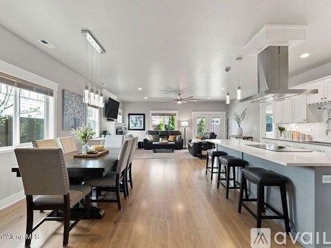 A modern kitchen with a dining table and bar stools.