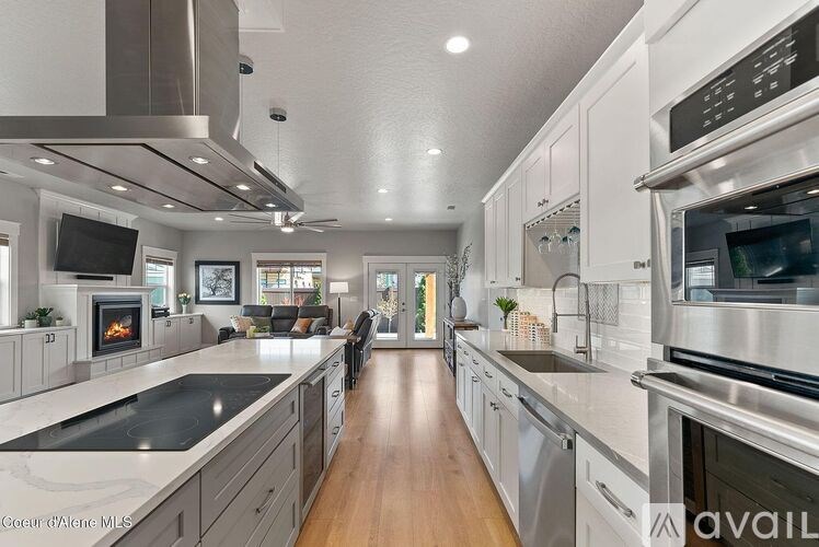 A modern kitchen with stainless steel appliances and wooden floors.