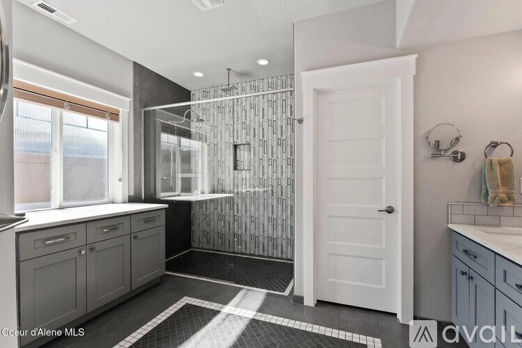 A bathroom with a walk-in shower and a white door.