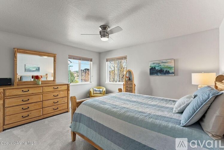 A bedroom with a bed, dresser, and a painting on the wall.