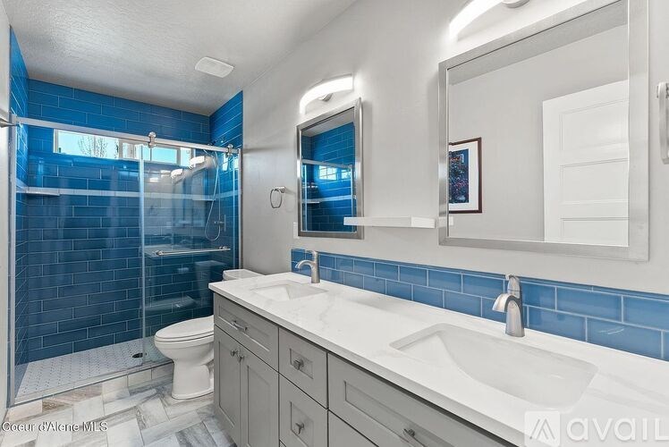 A bathroom with blue tiles and a white sink.