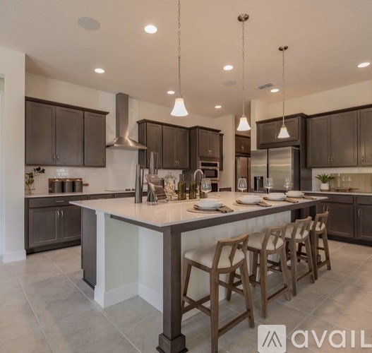A modern kitchen with dark brown cabinets and a central island.