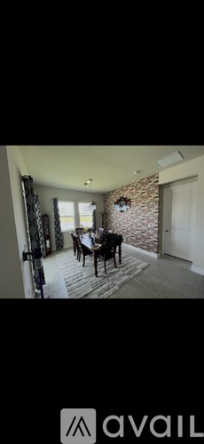 A dining room with a brick wall and a wooden table.