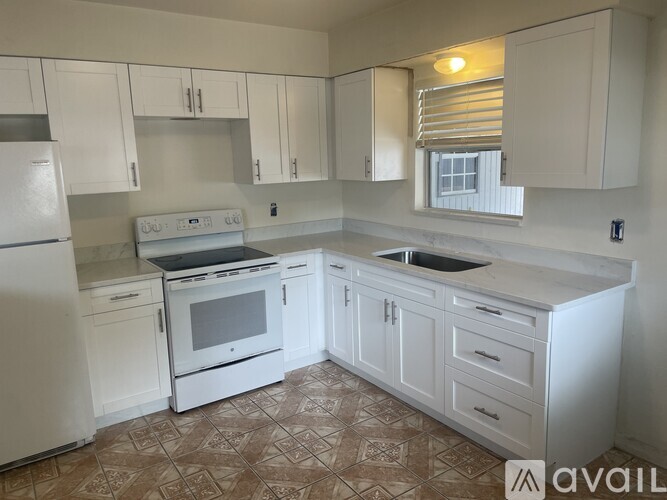 A kitchen with white appliances and cabinets.