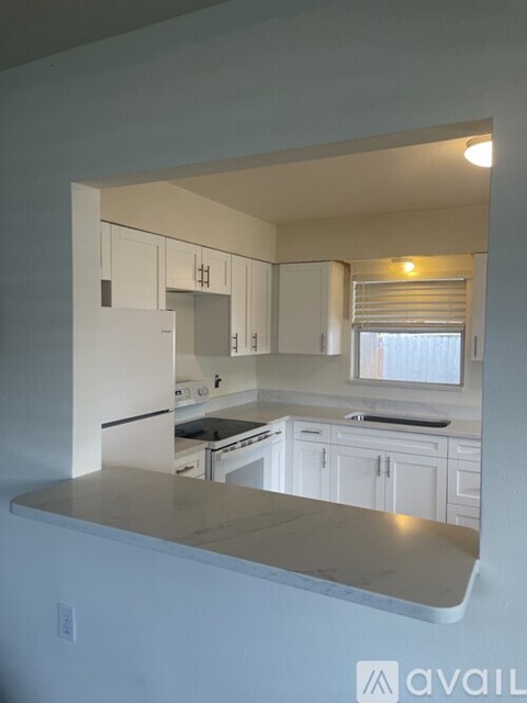 A kitchen with white cabinets and appliances.
