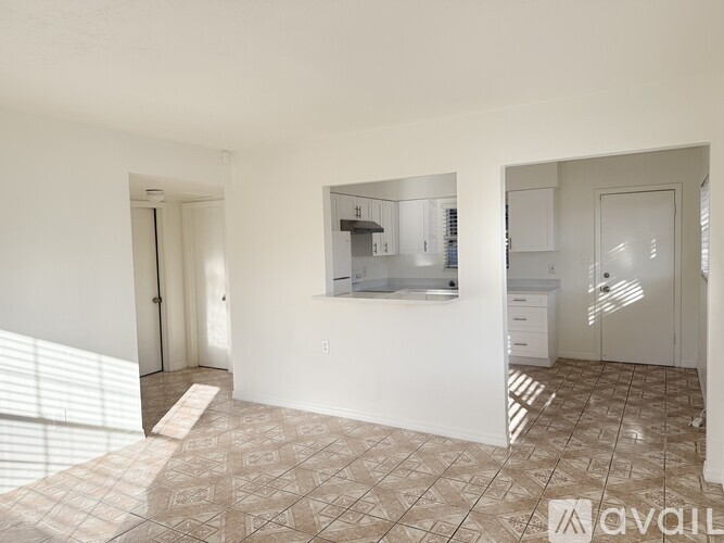 A living room with a tiled floor and a large mirror on the wall.