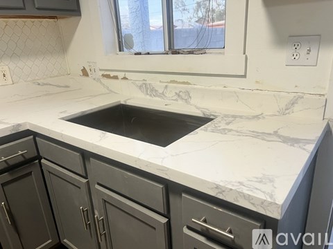 A kitchen counter with a sink and a window.