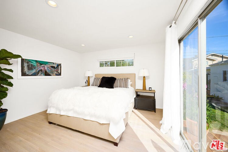 A bedroom with a large bed and a painting on the wall.