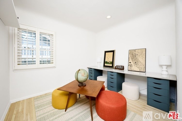 A room with a desk, a chair, and a globe on it.