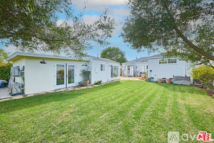 A white house with a green lawn in front.