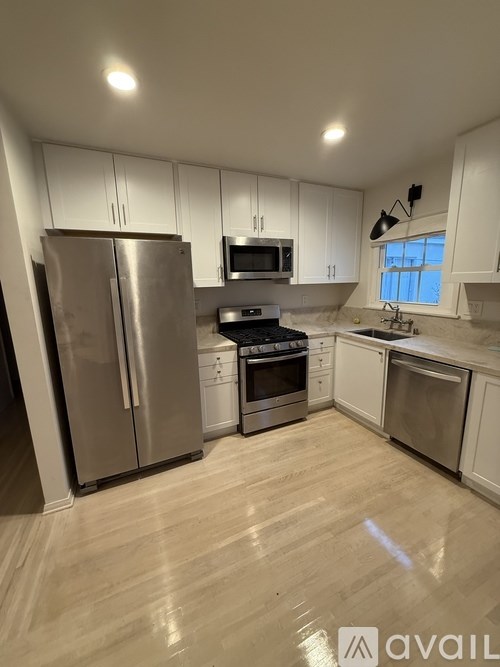 A kitchen with white cabinets and stainless steel appliances.