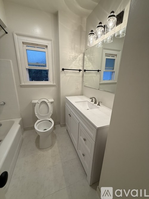 A bathroom with a toilet, sink, and tub.