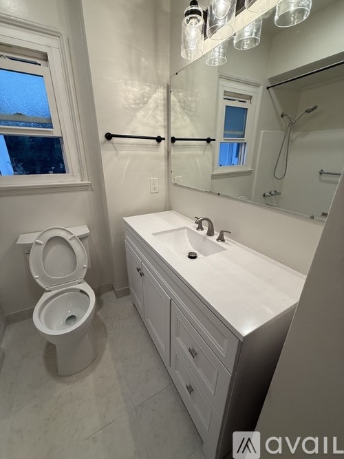 A bathroom with a toilet, sink, and mirror.