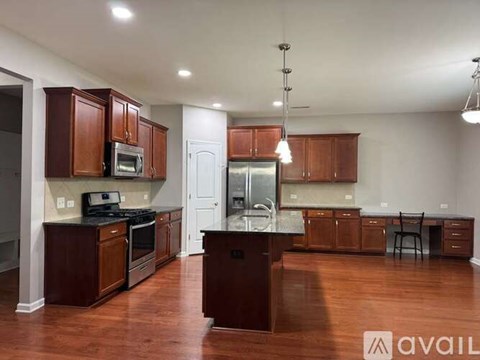 A kitchen with brown cabinets and a black countertop.