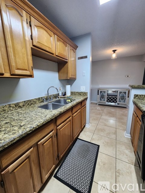 A kitchen with wooden cabinets and granite countertops.