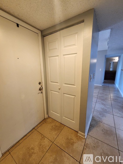A white door is in a room with tiled flooring.
