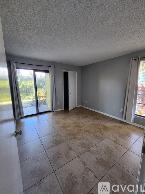 A room with tile flooring and sliding glass doors.