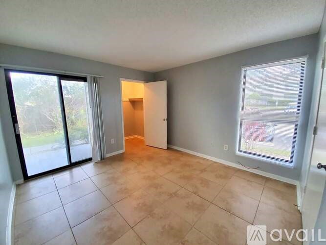 A room with a sliding glass door and a tiled floor.