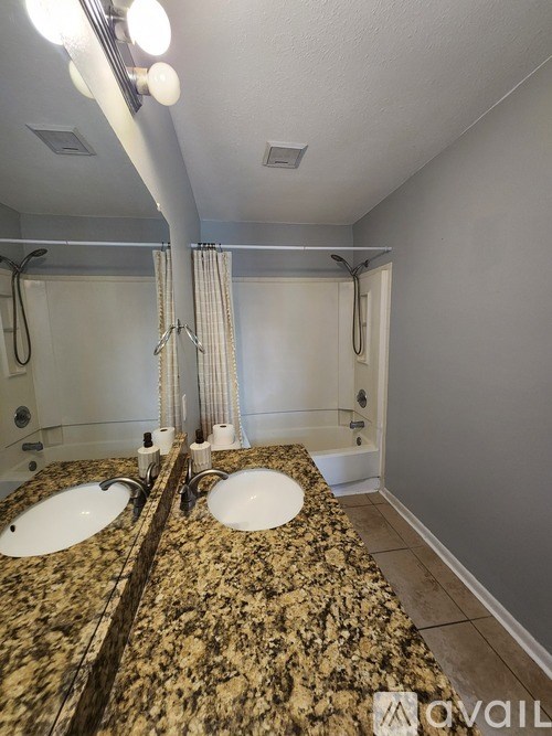 A bathroom with granite countertops and double sinks.