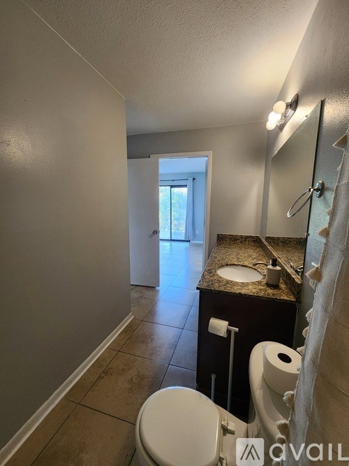 A bathroom with a toilet, sink, and mirror.