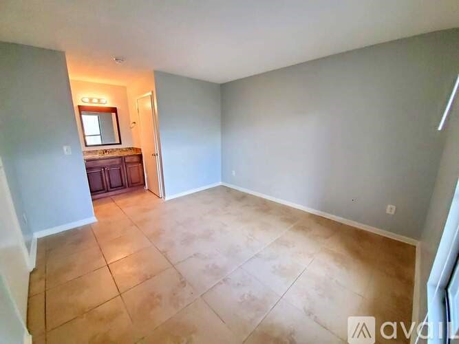 A room with tiled flooring and a mirror on the wall.