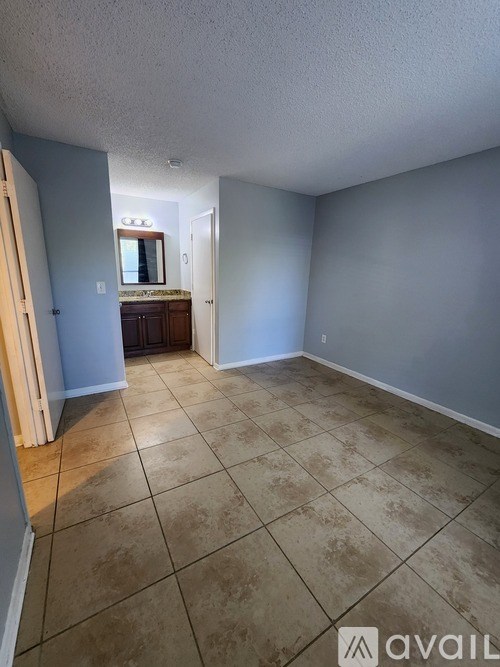 A room with a tiled floor and a mirror on the wall.