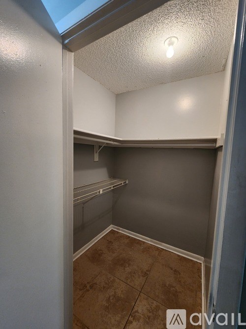 A small, empty room with a skylight and a single shelf.