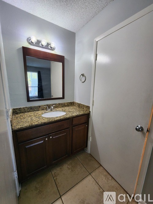 A bathroom with a sink, mirror, and cabinets.