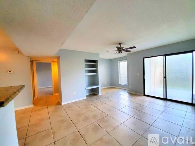A spacious room with a ceiling fan and sliding glass doors.
