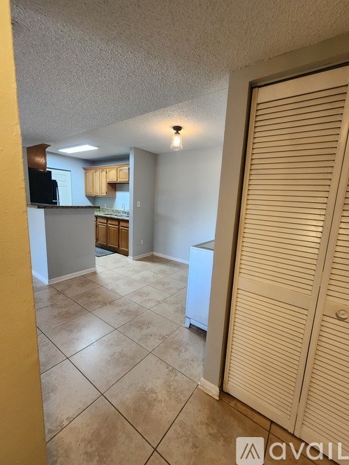 A kitchen area with a refrigerator, microwave, and cabinets.